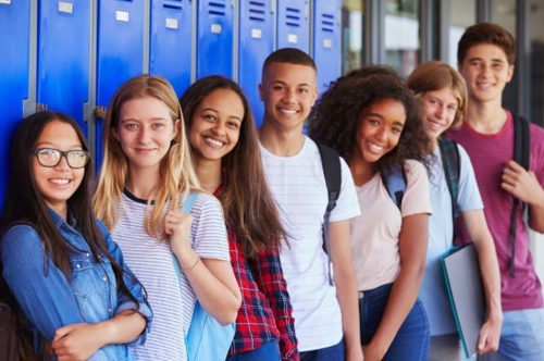 group of high school freshmen leaning against lockers