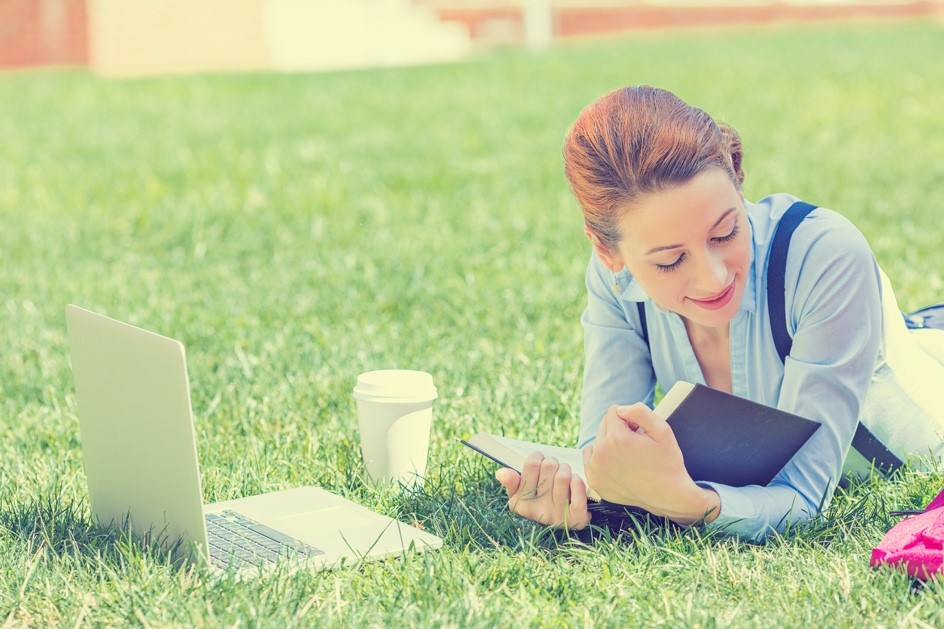 Girl Reading Book On Grass